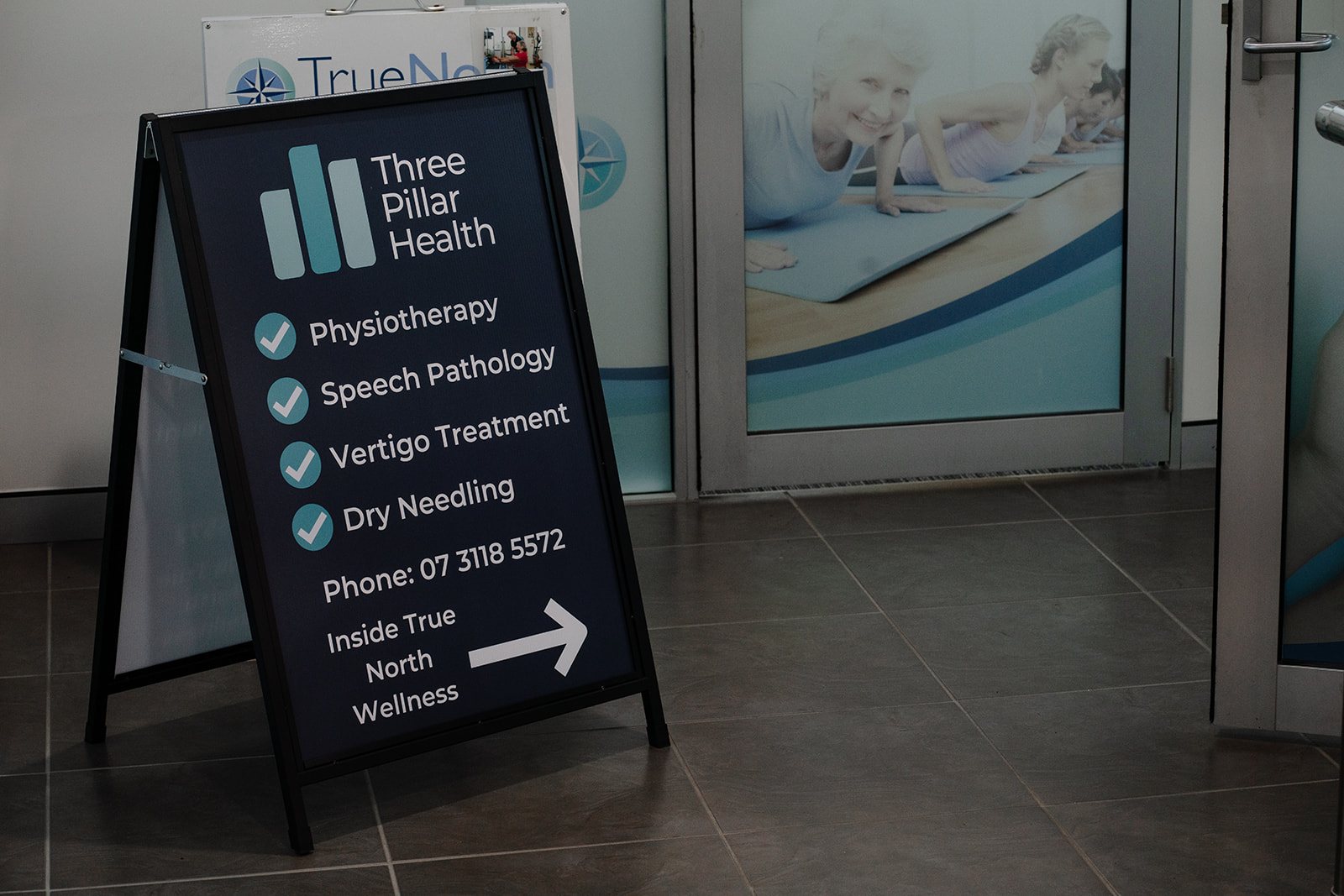 The Three Pillar Health sign at the clinic entrance, inside True North Wellness