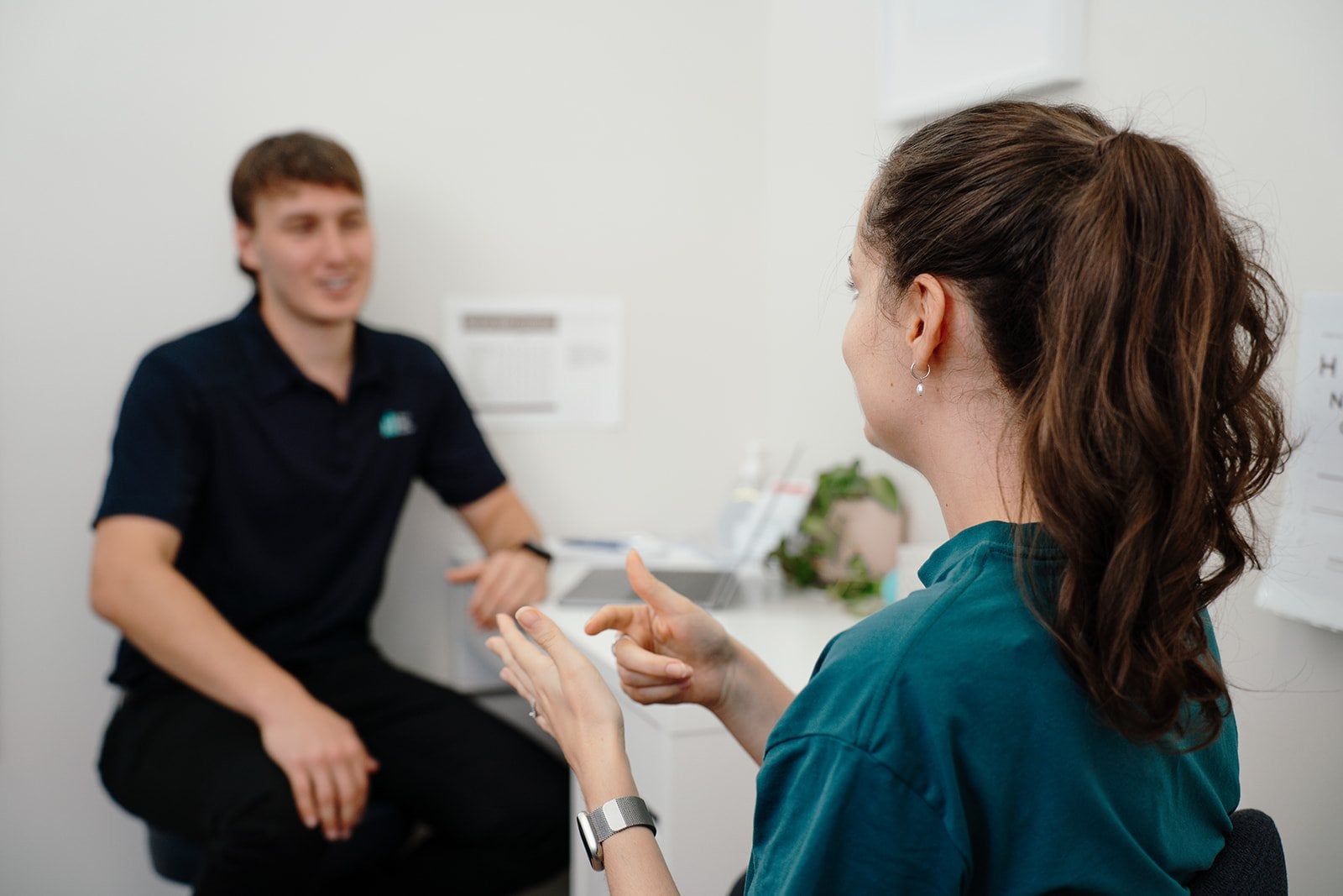 Physiotherapist Jarred Megaw explaining something to a patient at the desk