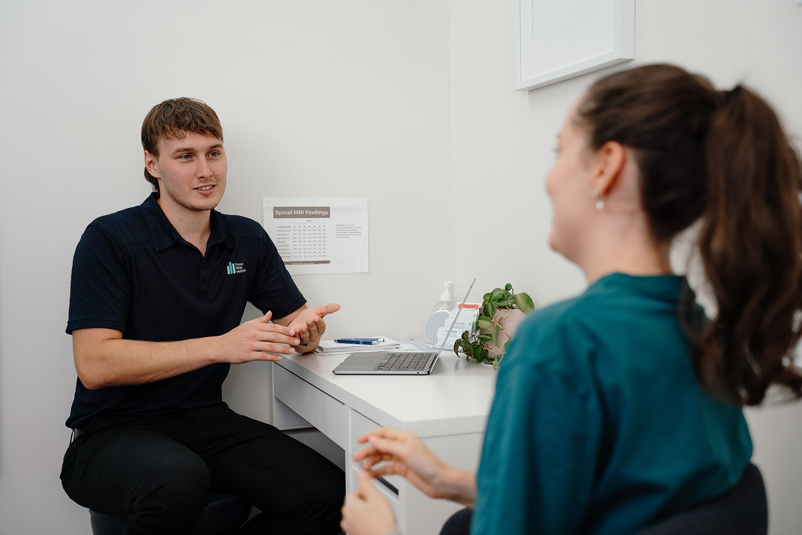 Jarred talking with a patient at the desk