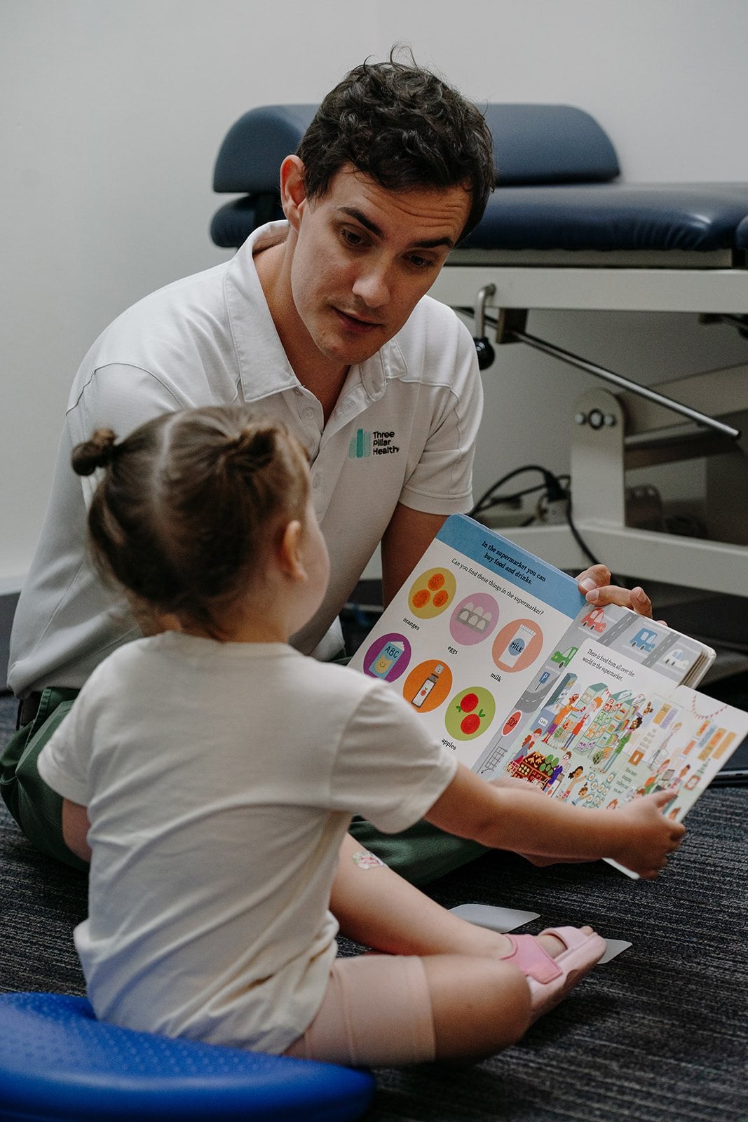 Speech pathologist Jonathon Cronk sharing a picture book with a young child during a session