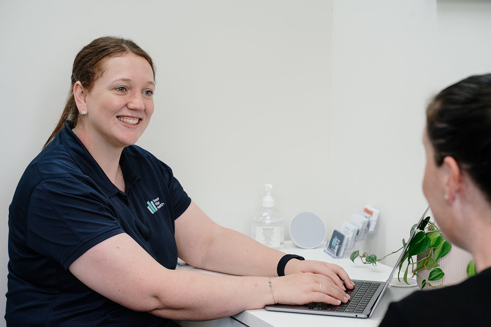 Kylie at the desk with a patient