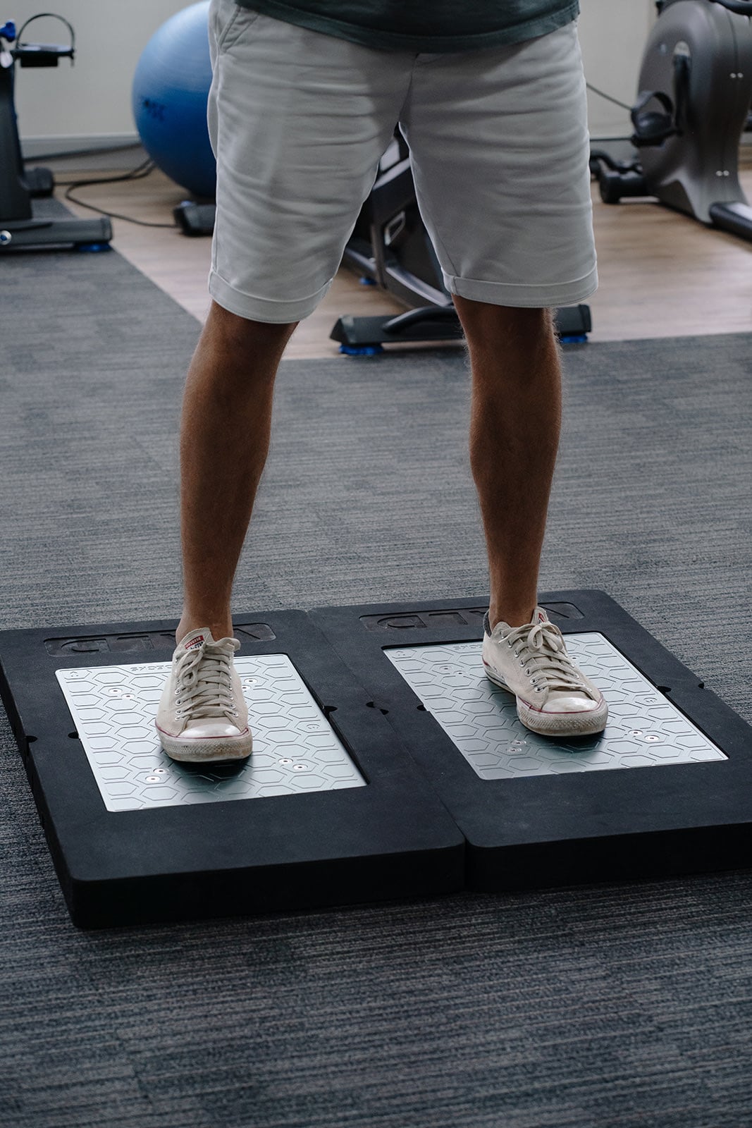 A patient standing on the VALD force plates
